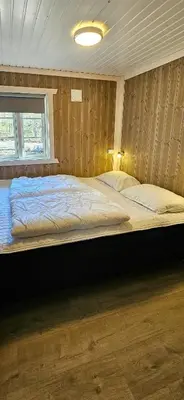 a bedroom with a large bed with a window at Cabin At The Foot Of Andersnatten in Engar