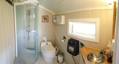 a bathroom with a shower and a toilet and a sink at Cabin At The Foot Of Andersnatten in Engar