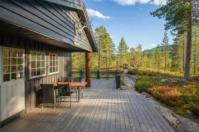 a porch of a house with a table and chairs at Cabin At The Foot Of Andersnatten in Engar