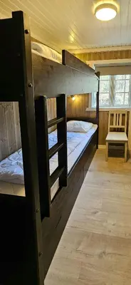a room with two bunk beds and a bench at Cabin At The Foot Of Andersnatten in Engar