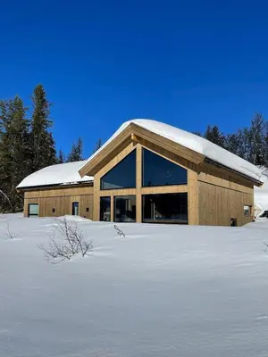 a building with snow on top of a snow covered field at Lovely Cabin With Hot Tub Near Syningtoppen in Torpo