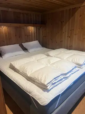 a large bed in a room with wooden walls at Charming and modern ski-in ski-out cottage in Hemsedal