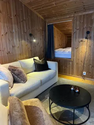 a living room with a couch and a table at Charming and modern ski-in ski-out cottage in Hemsedal