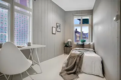 a bedroom with a bed and a desk and a chair at Koselig sentrumsleilighet - Nær Bryggen in Bergen