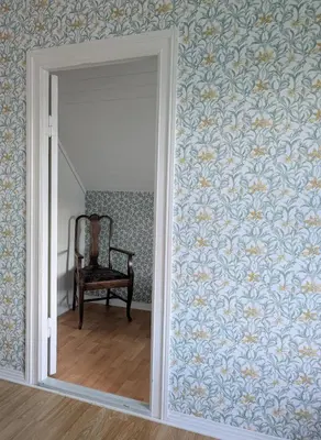 an empty room with a mirror and a chair at Lundenhuset 1917 - historic house in the heart of Ulsteinvik in Ulstein