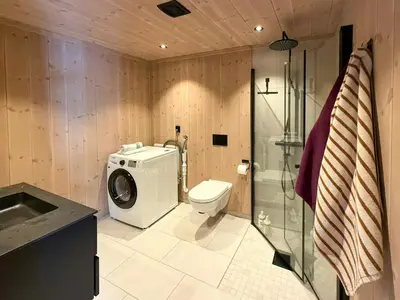 a bathroom with a washing machine and a toilet at Modern Cabin With Ski-Inout Near Birken Trails in Rena