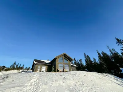 a house on top of a snow covered hill at Modern Cabin With Ski-Inout Near Birken Trails in Rena