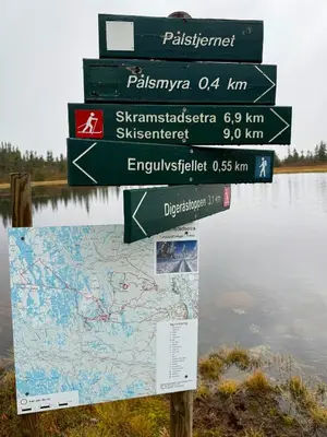 a sign in front of a lake with several signs at Modern Cabin With Ski-Inout Near Birken Trails in Rena