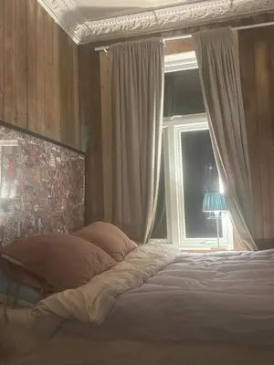 a bedroom with a bed and a window with a lamp at Central, charming, 1800s apartment in Lii