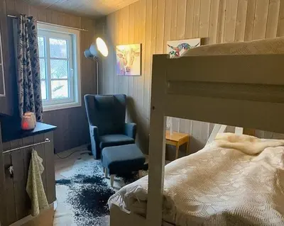 a bedroom with a bunk bed and a chair at Enjoy Days In Traditional Log Cabin in Uvdal