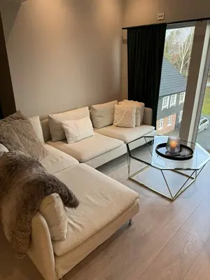 a living room with a couch and a glass table at Penthouse apartment 2 bedrooms 70 m2 in Verdal