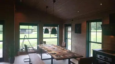 a long wooden table in a room with windows at Cabin With Ski Inout Near Stryn Alpine Resort in Stryn