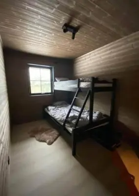 a bunk bed in a small room with a window at Cabin With Ski Inout Near Stryn Alpine Resort in Stryn