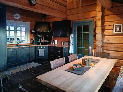 a kitchen with a wooden table with a candle on it at Log Cabin Near Muen And Myafallene in Venabygd