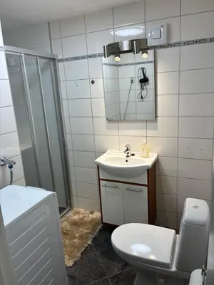 a bathroom with a sink and a toilet and a mirror at Alesund apartment fantastic view in Ålesund