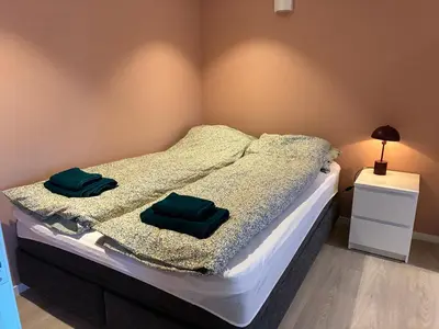 a bedroom with a bed with two green pillows on it at Alesund apartment fantastic view in Ålesund