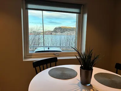 a table with two chairs in front of a window at Alesund apartment fantastic view in Ålesund