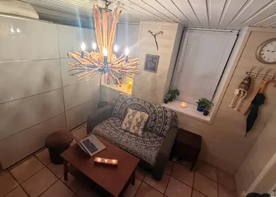 a room with a chair and a table and a clock at Cozy little apartment at the back of Bryggen in Bergen