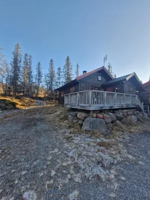 a large house with a porch and rocks in front of it at Fjellvang in Haglebu