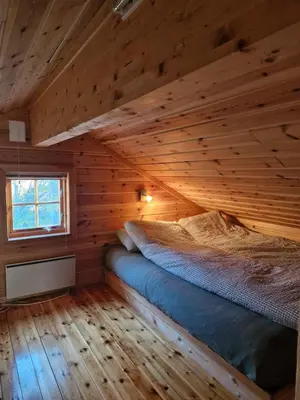a bedroom with a bed in a wooden cabin at Fjellvang in Haglebu
