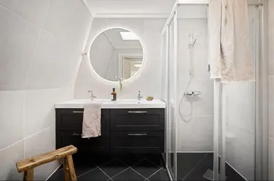 a bathroom with a sink and a shower with a mirror at Spacious Group Villa with Jacuzzi and Views in Askøy