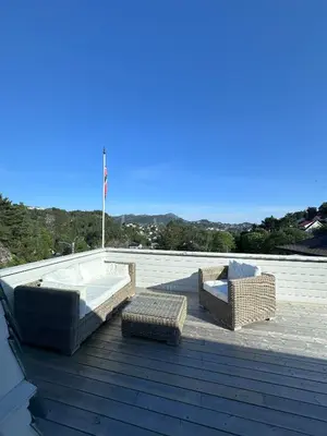 a patio with two chairs and a tub on a roof at Spacious Group Villa with Jacuzzi and Views in Askøy