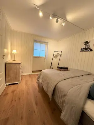 a bedroom with a bed and a dresser and a window at Spacious Group Villa with Jacuzzi and Views in Askøy