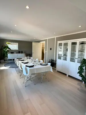 a dining room with white tables and white chairs at Spacious Group Villa with Jacuzzi and Views in Askøy