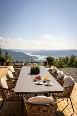a table and chairs on a wooden deck with a view at Viking Lodge Panorama-Norefjell in Noresund