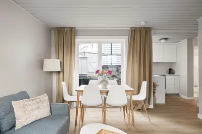 a living room with a table and white chairs at Central Bergen - Stylish & Cozy in Bergen