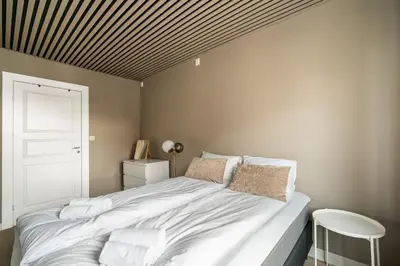 a bedroom with a large white bed with a wooden ceiling at Central Bergen - Stylish & Cozy in Bergen