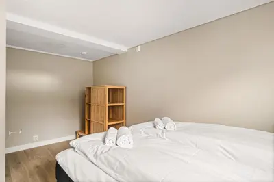 a bedroom with two white beds and a book shelf at Central Bergen - Stylish & Cozy in Bergen