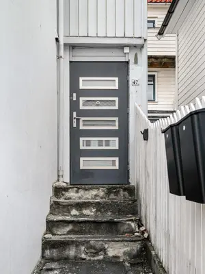 a garage door with stairs leading to a house at Central Bergen - Stylish & Cozy in Bergen
