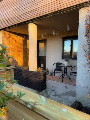 a porch of a house with a table and chairs at Soft Stay Apartment in Bergen