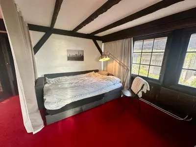 a bedroom with a bed and a red carpet at Hilltop Panorama view retreat in Ålesund