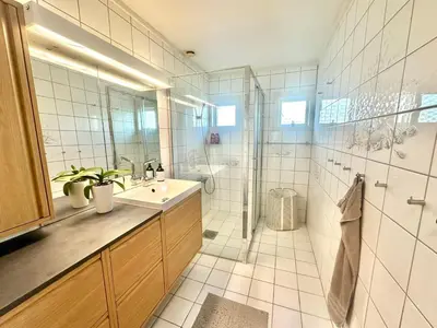 a bathroom with a sink and a shower at Hilltop Panorama view retreat in Ålesund
