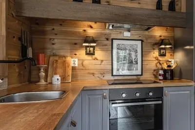 a kitchen with wooden walls and a sink at Charming cabin in Hemsedal Golf Alpin - ideal for families, fishing & skiing in Hemsedal