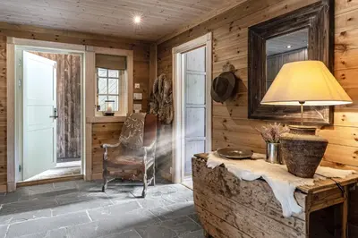 a room with a table and a chair and a lamp at Charming cabin in Hemsedal Golf Alpin - ideal for families, fishing & skiing in Hemsedal