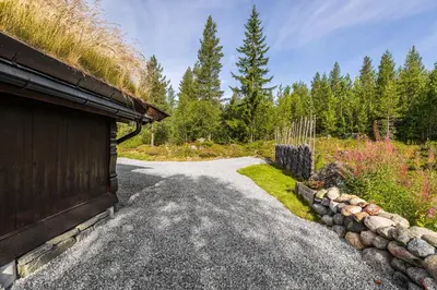 a driveway to a house with a grass roof at Charming cabin in Hemsedal Golf Alpin - ideal for families, fishing & skiing in Hemsedal