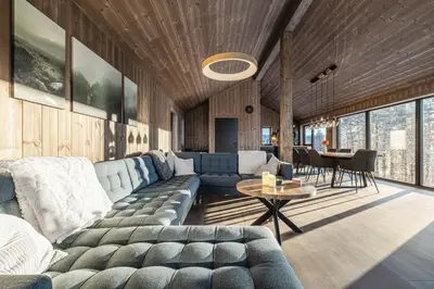 a living room with a couch and a table at New luxury cabin in Geilo with hot tub, mountain views & ski access in Geilo