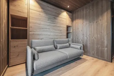 a couch in a room with wooden walls at New luxury cabin in Geilo with hot tub, mountain views & ski access in Geilo