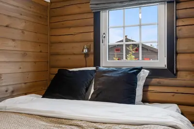 a bed with pillows in a room with a window at Vikinggrenda 16A by Vacation Trysil in Trysil