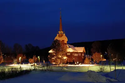 a large church with a steeple at night at Trudvang Apartment Hotel in Rena
