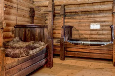 a room with two beds in a log cabin at Jørundgard Vikingcamp in Sel