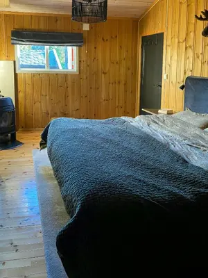 a bedroom with a bed in a room with wooden walls at Cabin With Ski Inout Near Gribbe, Valdres in Tisleidalen