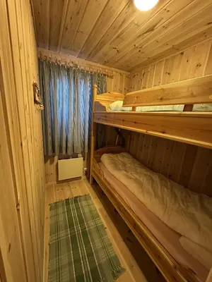 two bunk beds in a wooden cabin with a window at Family cabin in Hafjell, ski in-ski out in Hafjell