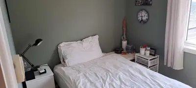 a bedroom with a bed and a clock on the wall at Grodås Lake View Apartment in Hornindal