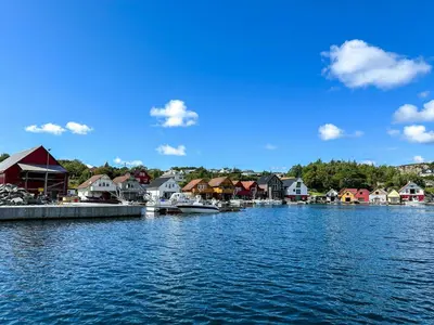 a town on the water with houses and boats at Fishermen's Cabin With Sea View in Bømlo