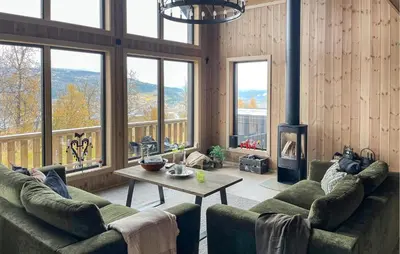 a living room with couches and a table and a fireplace at Amazing Home In Røn With Sauna in Ron
