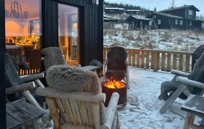 a porch with a fire pit in a rocking chair at Amazing Home In Røn With Sauna in Ron